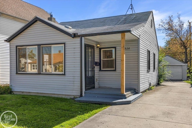 view of front of property with a front lawn, an outbuilding, and a garage