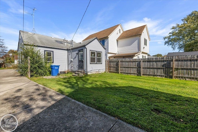 rear view of house featuring a lawn