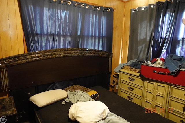 bedroom featuring wooden walls