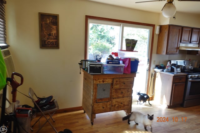 kitchen featuring stainless steel electric stove, light hardwood / wood-style floors, and ceiling fan