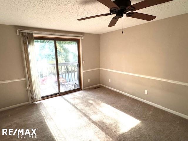 carpeted empty room featuring a textured ceiling and ceiling fan