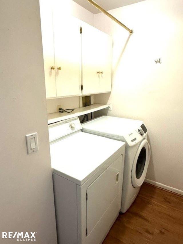 laundry area with hardwood / wood-style flooring, cabinets, and separate washer and dryer