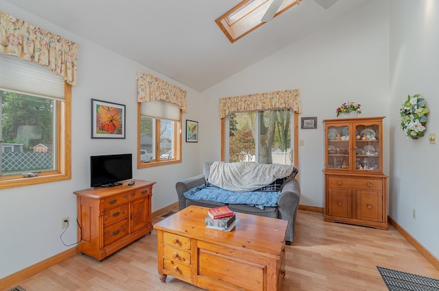 living room featuring light hardwood / wood-style floors and lofted ceiling with skylight