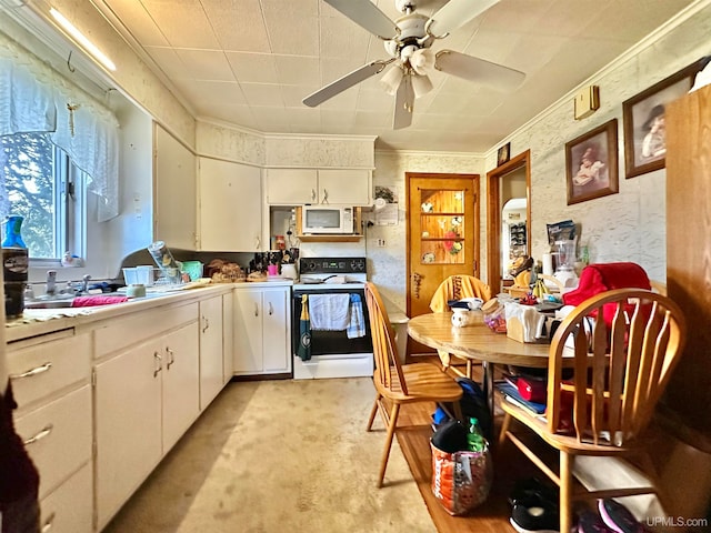 kitchen with light carpet, white appliances, ceiling fan, sink, and white cabinets