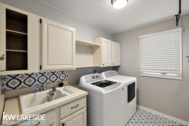 washroom featuring sink, cabinets, and washing machine and clothes dryer