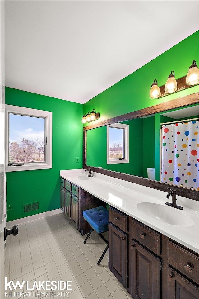 bathroom with toilet, vanity, tile patterned floors, and a shower with curtain