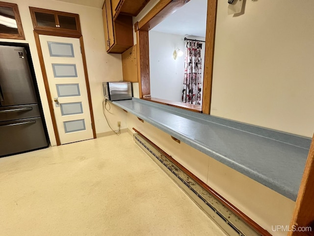 kitchen featuring stainless steel fridge and a baseboard radiator