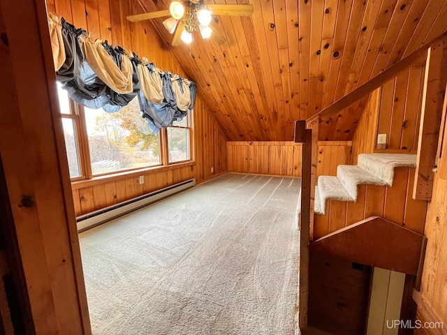 additional living space featuring a baseboard radiator, ceiling fan, carpet flooring, vaulted ceiling, and wooden walls