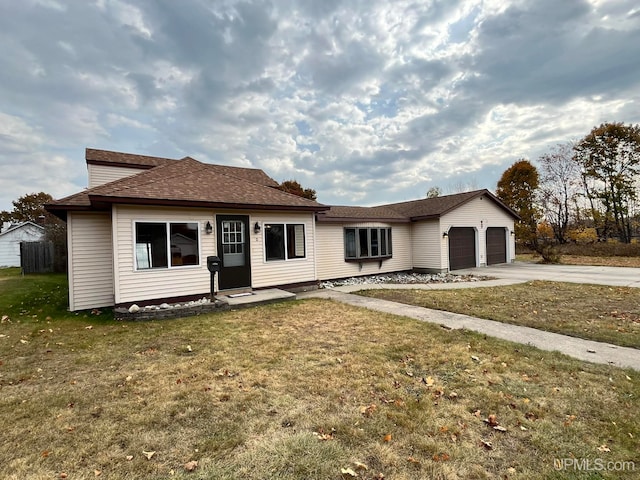 view of front of property featuring a front yard and a garage