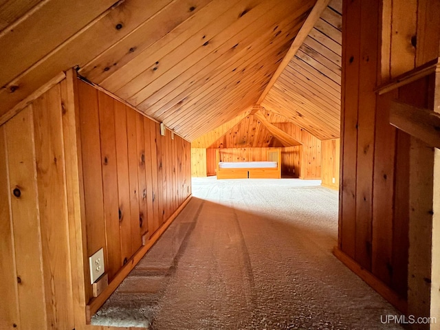 bonus room with lofted ceiling, wooden walls, and carpet flooring