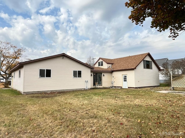 rear view of house featuring a yard