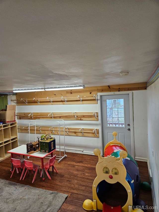 recreation room featuring a textured ceiling and hardwood / wood-style flooring