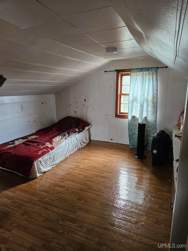 unfurnished bedroom featuring hardwood / wood-style floors and vaulted ceiling