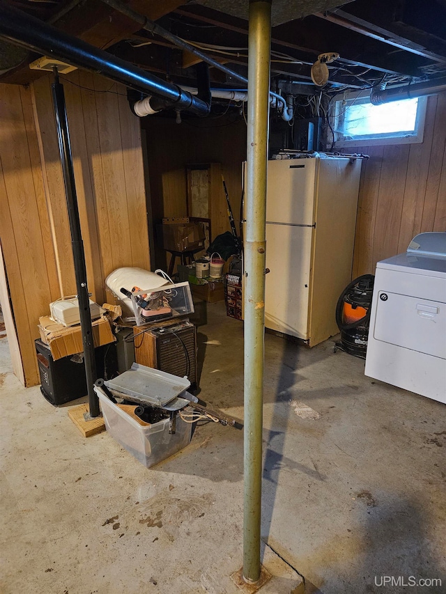 basement featuring washer / dryer and wooden walls