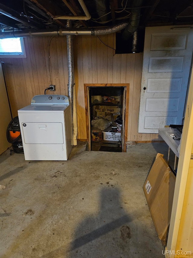 basement featuring washer / dryer and wooden walls