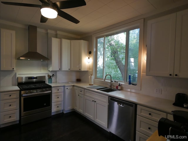 kitchen featuring white cabinets, ceiling fan, sink, wall chimney exhaust hood, and stainless steel appliances