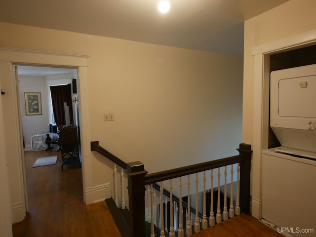 stairs with stacked washer / dryer and wood-type flooring