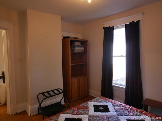 bedroom with hardwood / wood-style flooring and multiple windows