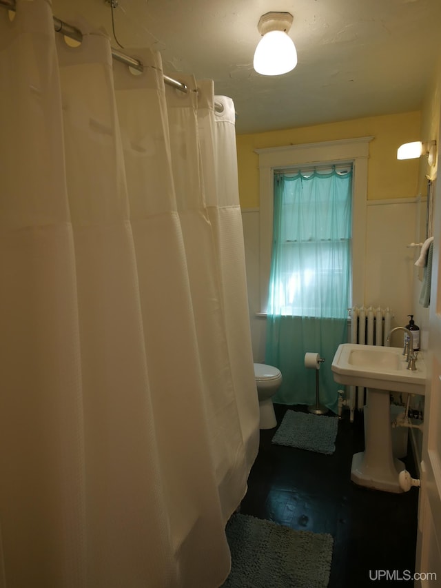 bathroom featuring toilet, radiator, and a shower with shower curtain