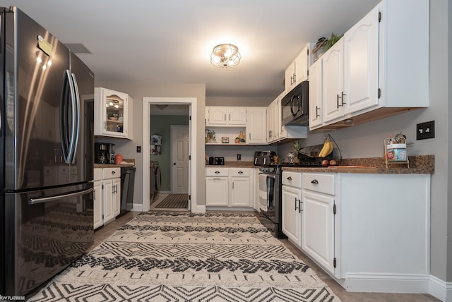 kitchen featuring white cabinets, stainless steel refrigerator, and range with electric cooktop