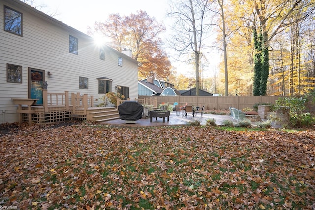 view of yard featuring a fire pit, a patio, and a deck