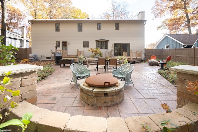 rear view of property featuring an outdoor fire pit and a patio