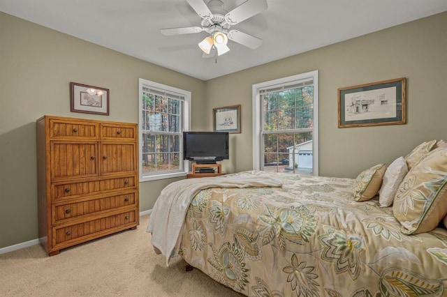 carpeted bedroom featuring multiple windows and ceiling fan