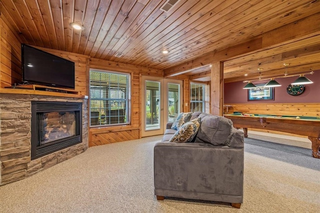 carpeted living room featuring wood ceiling, pool table, wooden walls, and a fireplace