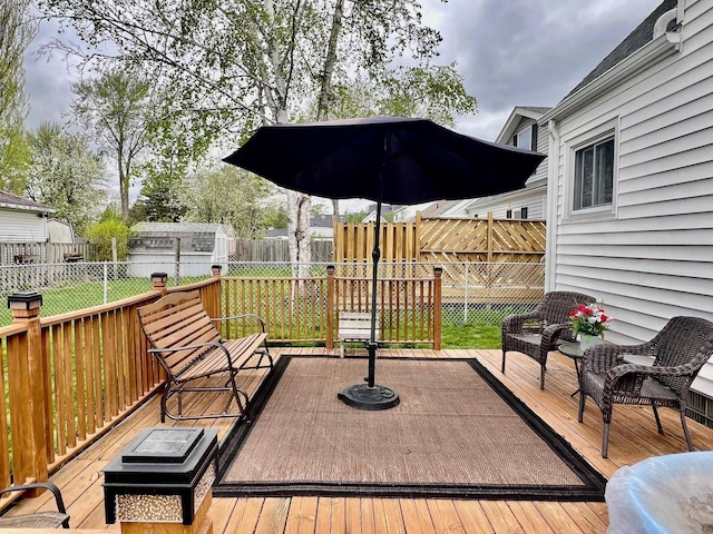 wooden terrace with a shed and a lawn