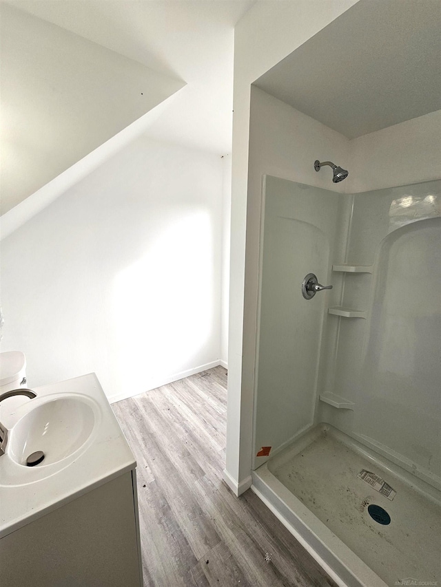 bathroom featuring vanity, a shower, and wood-type flooring