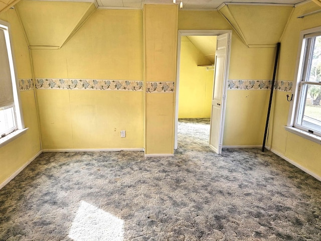 carpeted spare room featuring vaulted ceiling