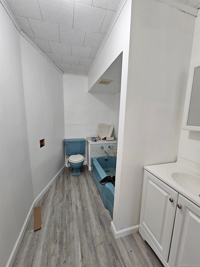 bathroom with vanity, wood-type flooring, toilet, and a bathing tub