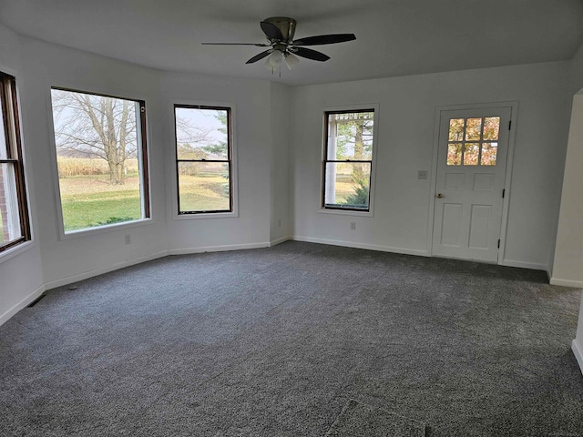 spare room with ceiling fan and dark carpet