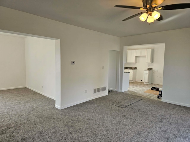 unfurnished living room with light carpet and ceiling fan