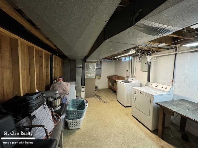 clothes washing area with heating unit, electric panel, and independent washer and dryer