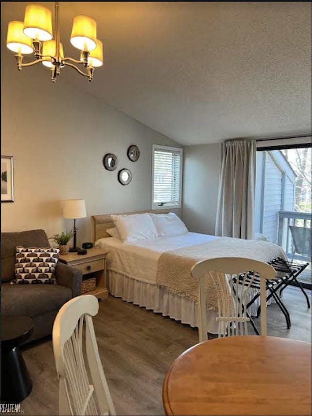 bedroom featuring multiple windows, hardwood / wood-style floors, a chandelier, and lofted ceiling