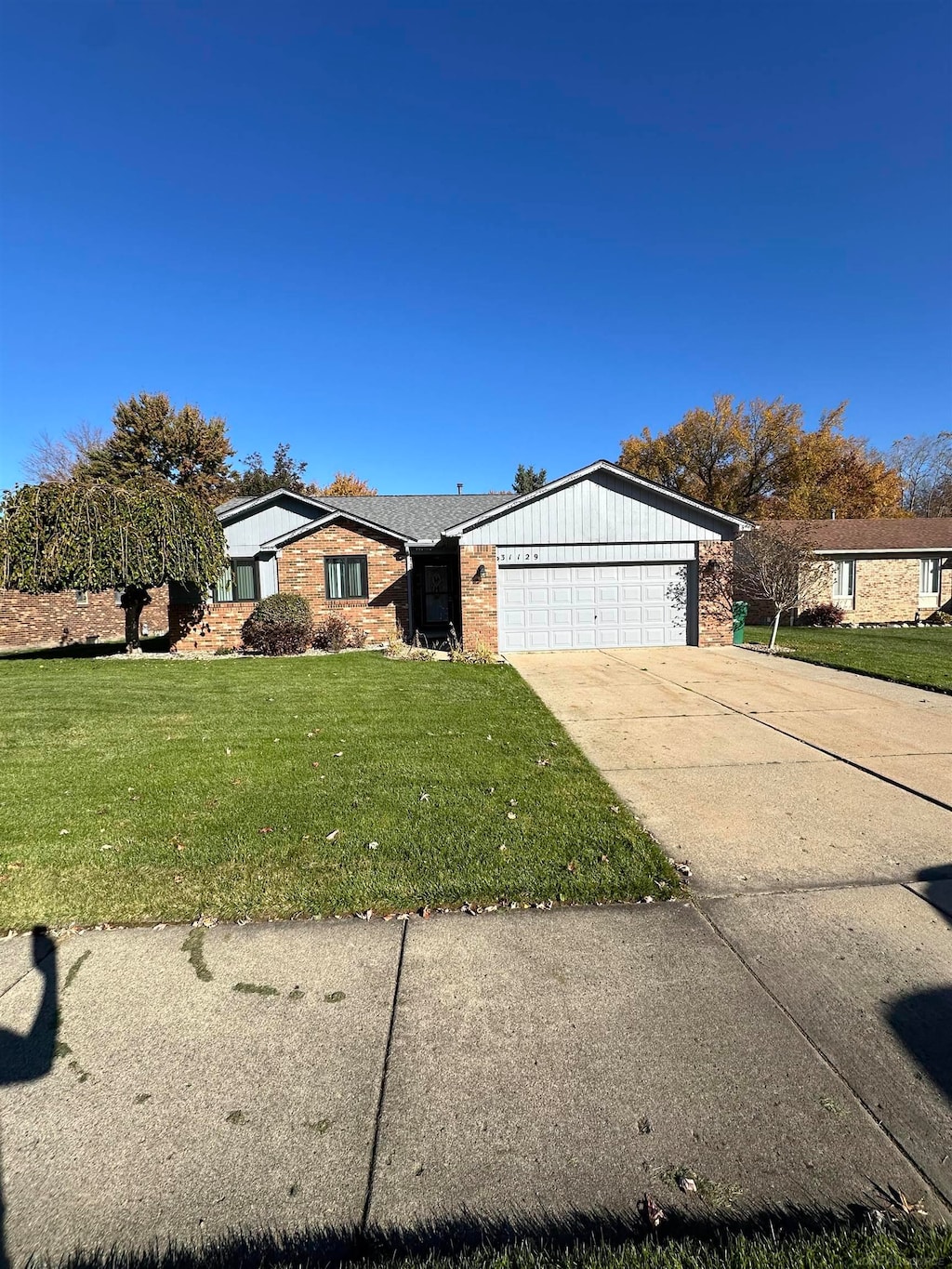 single story home with a garage and a front yard