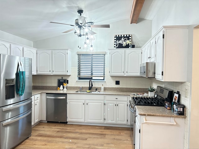 kitchen featuring stainless steel appliances, white cabinetry, sink, light wood-type flooring, and decorative backsplash