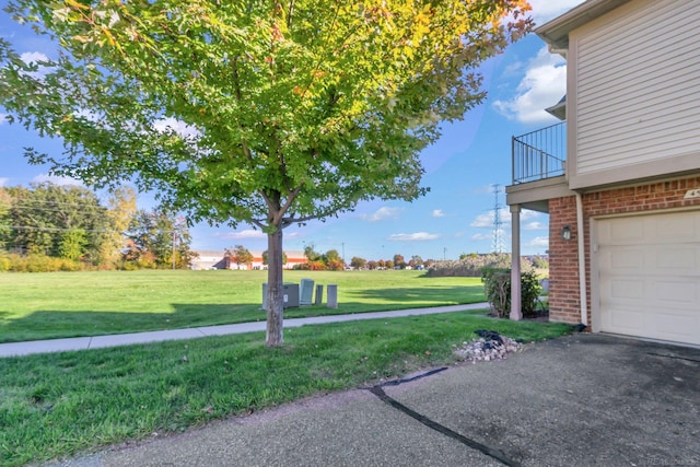 view of yard with a garage and a balcony