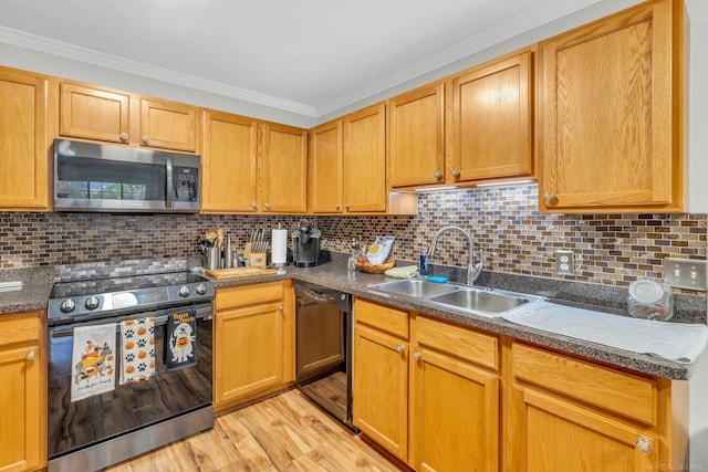 kitchen featuring appliances with stainless steel finishes, sink, light hardwood / wood-style floors, and backsplash