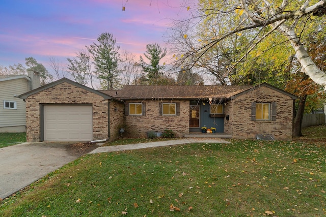 ranch-style house featuring a lawn and a garage