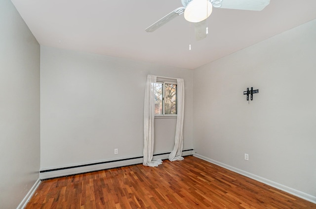 spare room featuring baseboard heating, wood-type flooring, and ceiling fan