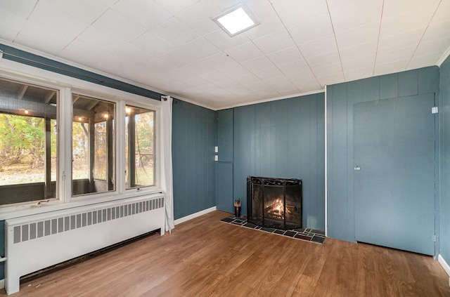 unfurnished living room featuring hardwood / wood-style floors and radiator heating unit