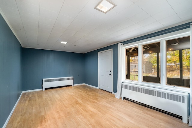 empty room featuring light wood-type flooring and radiator