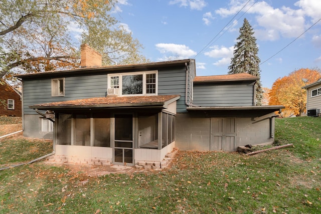 rear view of property with a yard and a sunroom