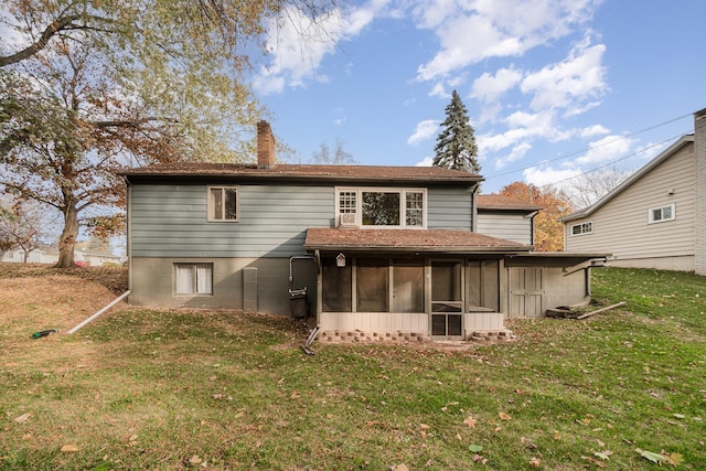 rear view of property with a lawn and a sunroom