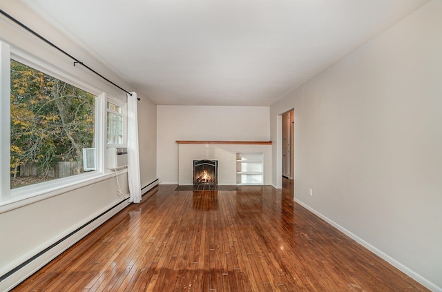 unfurnished living room featuring a baseboard heating unit, a fireplace, and hardwood / wood-style flooring