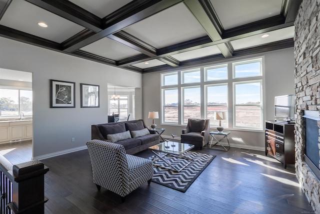 living room featuring a stone fireplace, beam ceiling, coffered ceiling, and dark hardwood / wood-style flooring