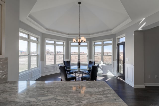 dining space featuring a tray ceiling, dark wood-type flooring, crown molding, and a chandelier