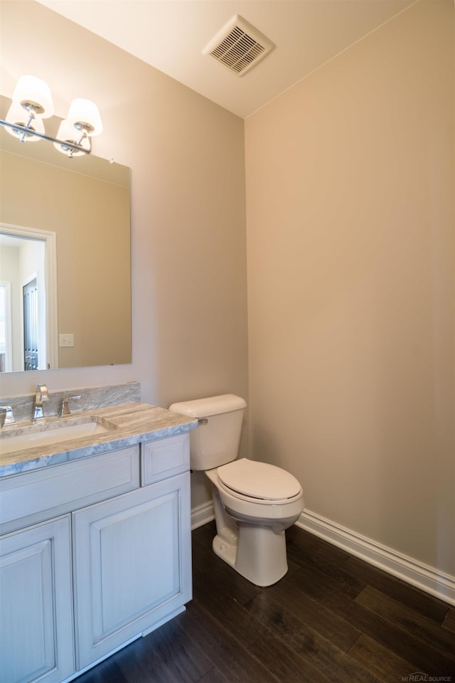 bathroom featuring vanity, wood-type flooring, and toilet